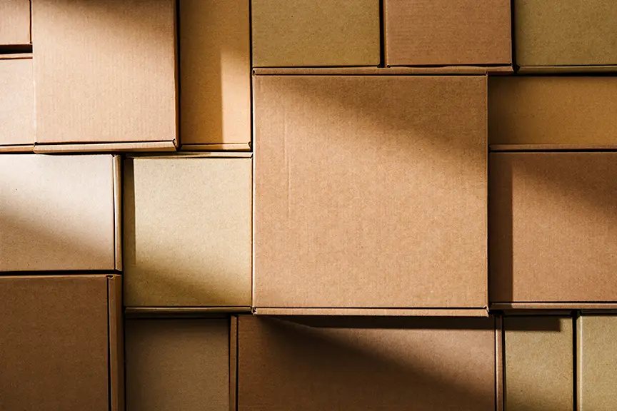 Stacked cardboard boxes arranged in a neat pattern under natural light